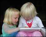 photo of two little girls reading a book