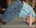 photo of toddler trying to stand on his head